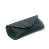 A green leather sunglass case with a magnetic button closure and a cotton-lined interior.